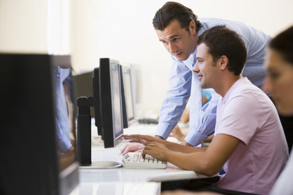 Man assisting other man in computer room